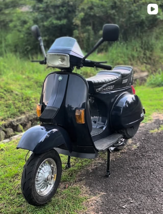 Vespa hitam dengan lampu kotak dan jok hitam