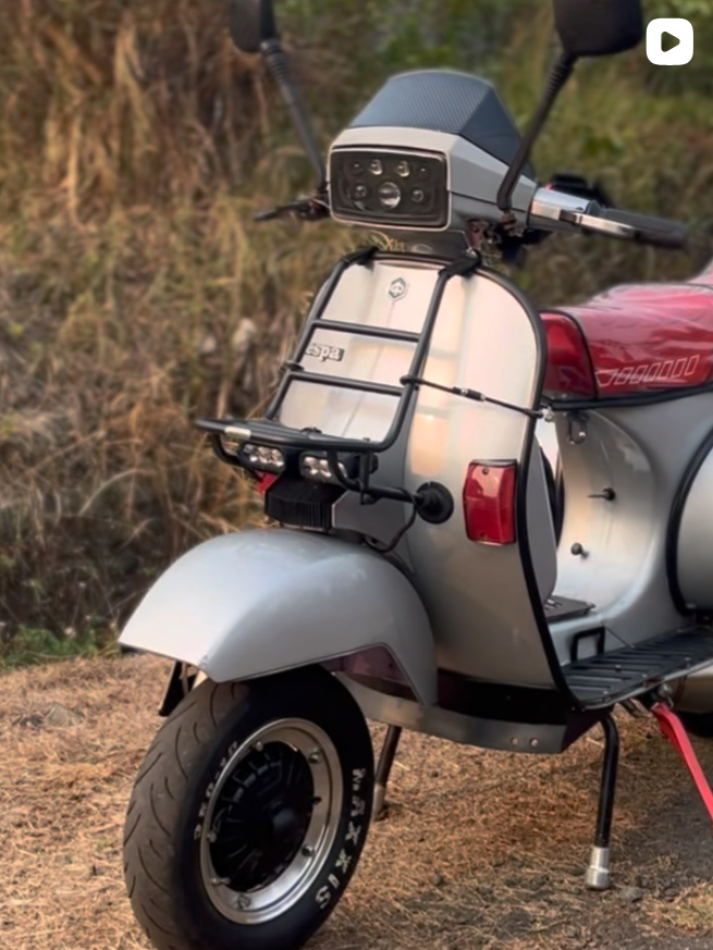 Vespa silver dengan jok merah dan rak depan